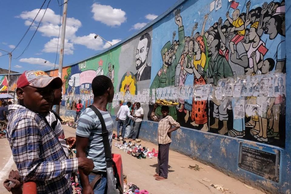 WOMAN STANDING IN GRAFFITI