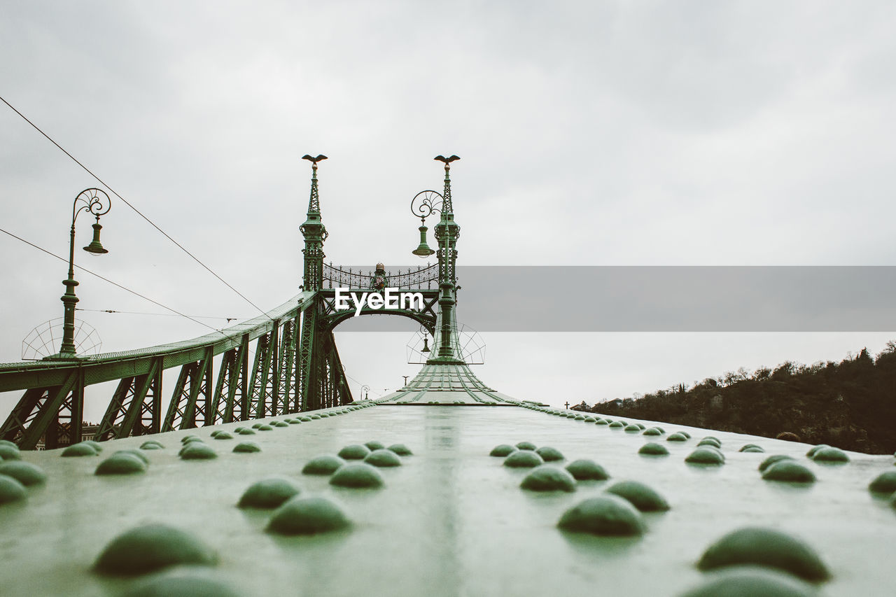 Low angle view of bridge against cloudy sky