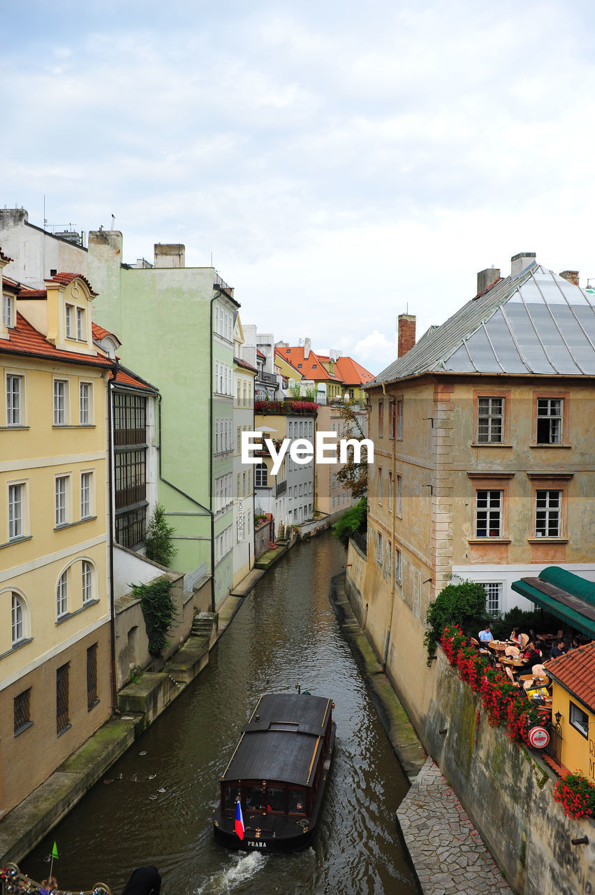 Ferry boat in canal amidst houses in town