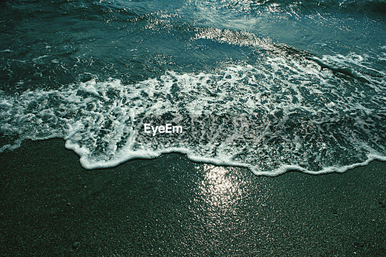 HIGH ANGLE VIEW OF WAVES ON BEACH