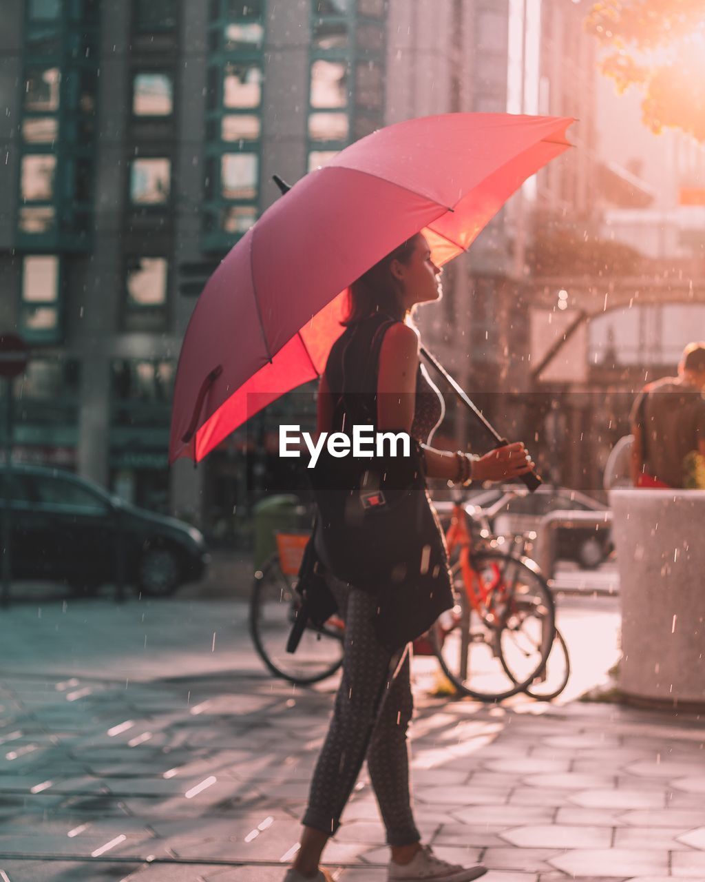 Full length of woman with umbrella walking in city during rainy season