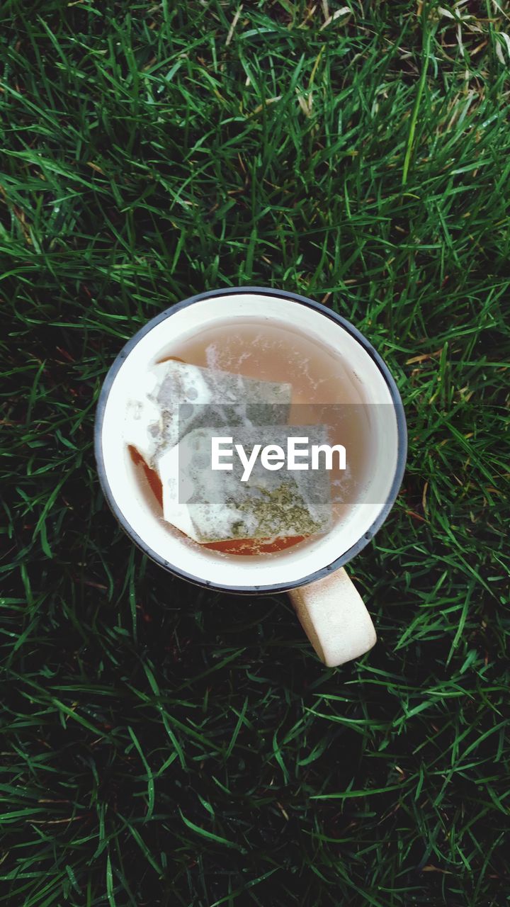 Directly above shot of teabags in cup on grass