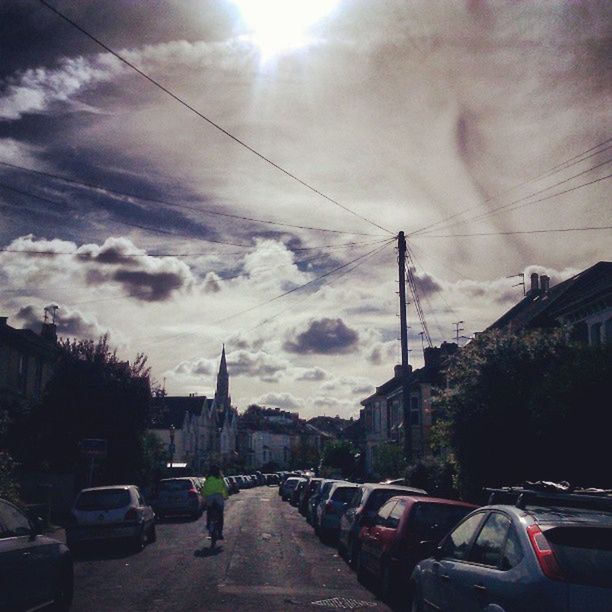 TRAFFIC ON ROAD AGAINST CLOUDY SKY