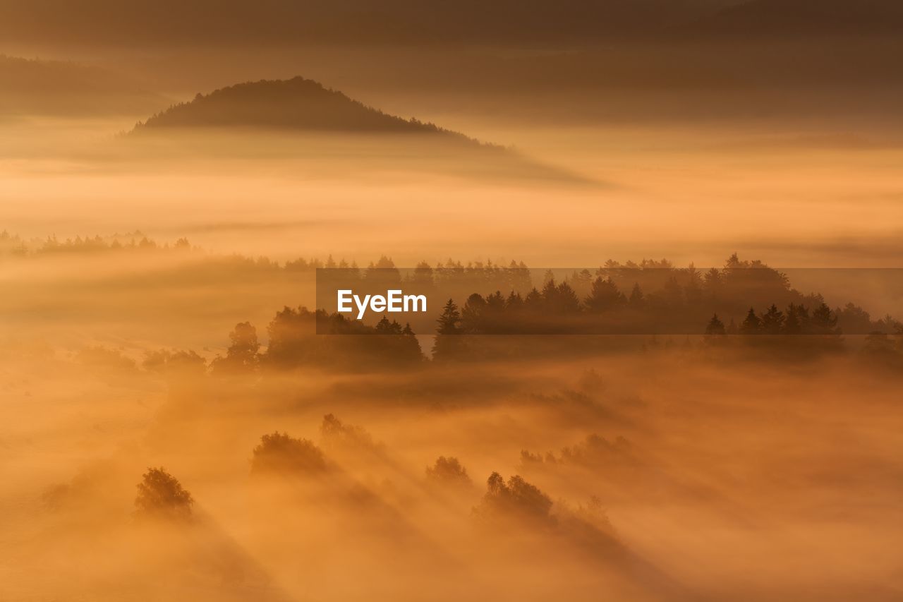 SCENIC VIEW OF MOUNTAINS AGAINST ORANGE SKY