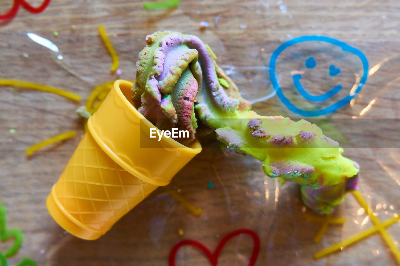 HIGH ANGLE VIEW OF MULTI COLORED CANDIES ON WOODEN TABLE