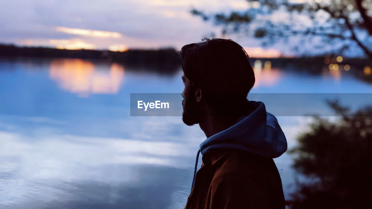 Portrait of silhouette man standing by lake against sky