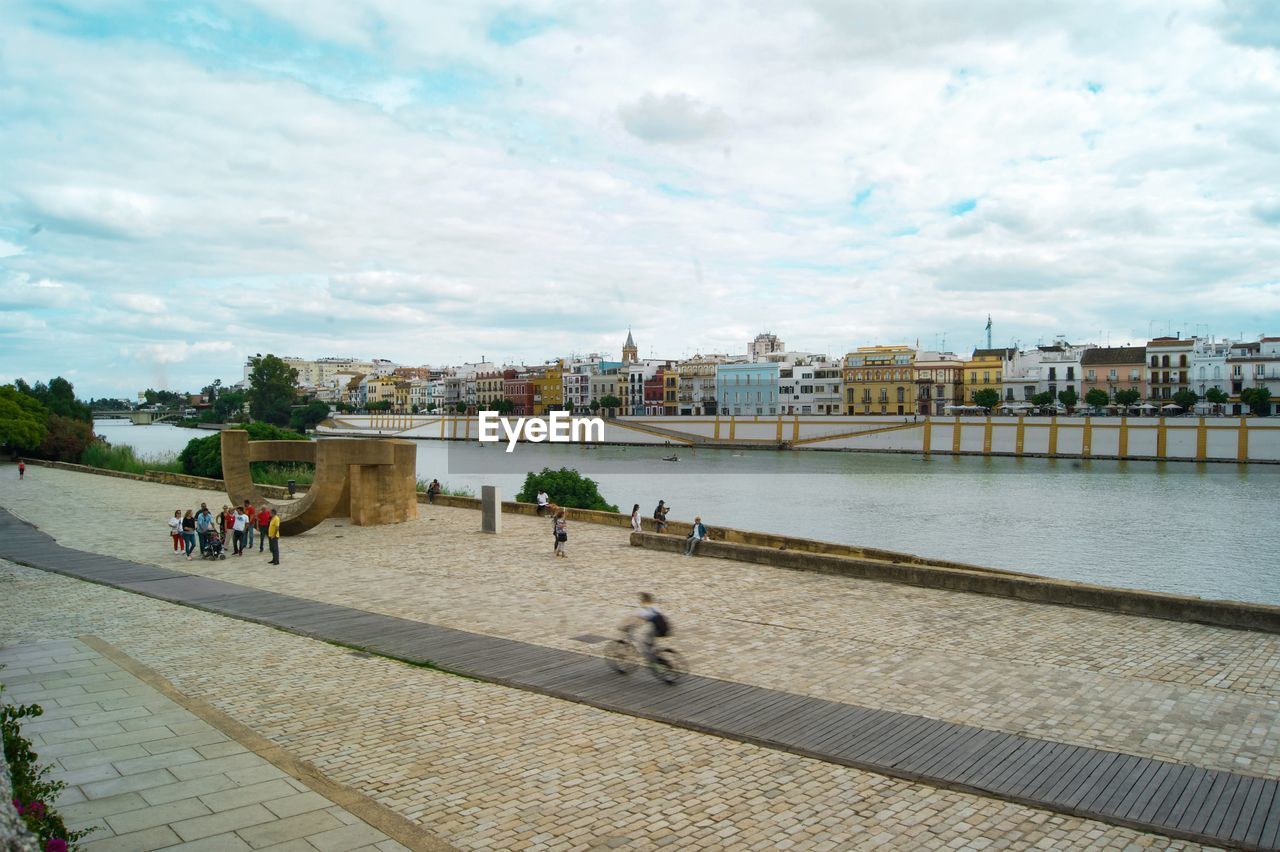 PEOPLE WALKING ON BRIDGE OVER RIVER