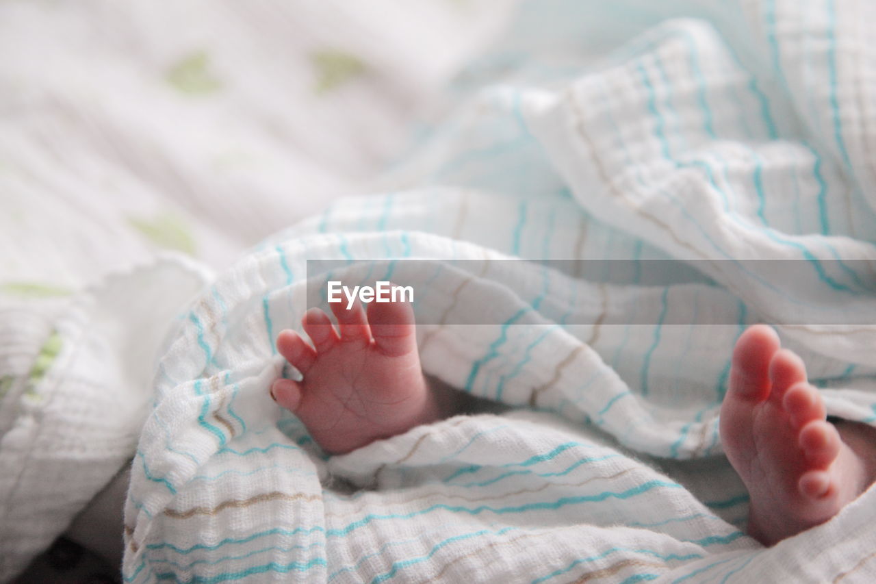 Close-up of baby feet on bed