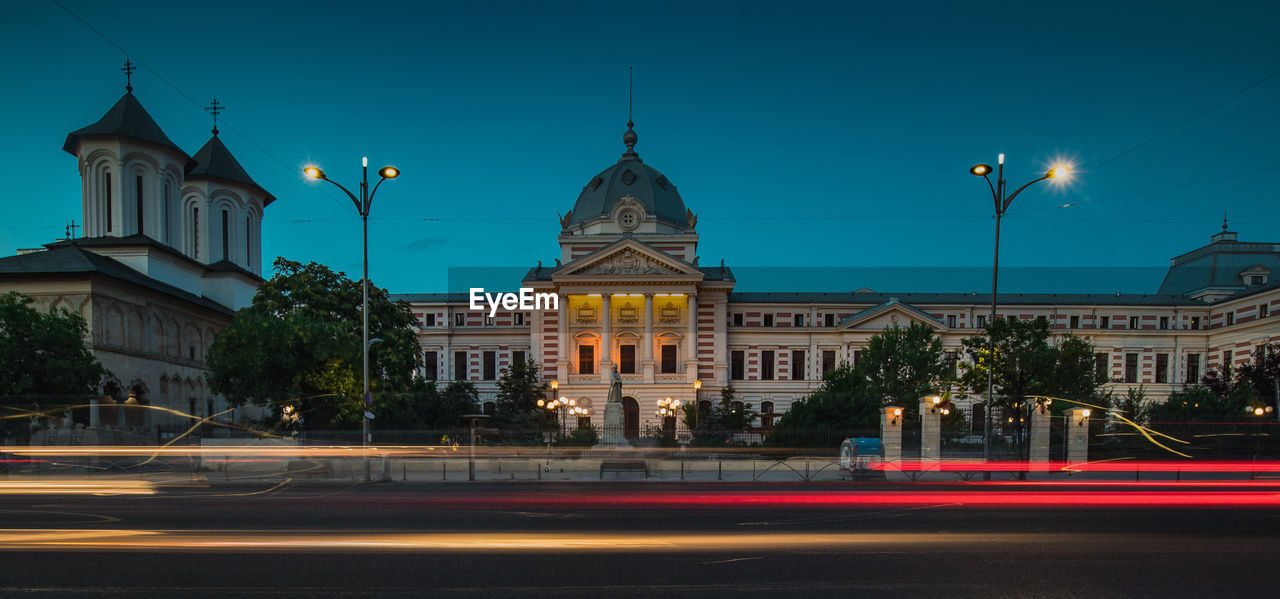 LIGHT TRAILS ON BUILDING AGAINST SKY