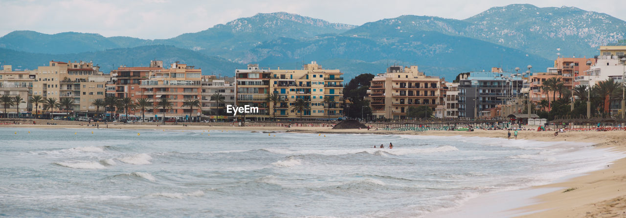 Panoramic view of beach with city in background