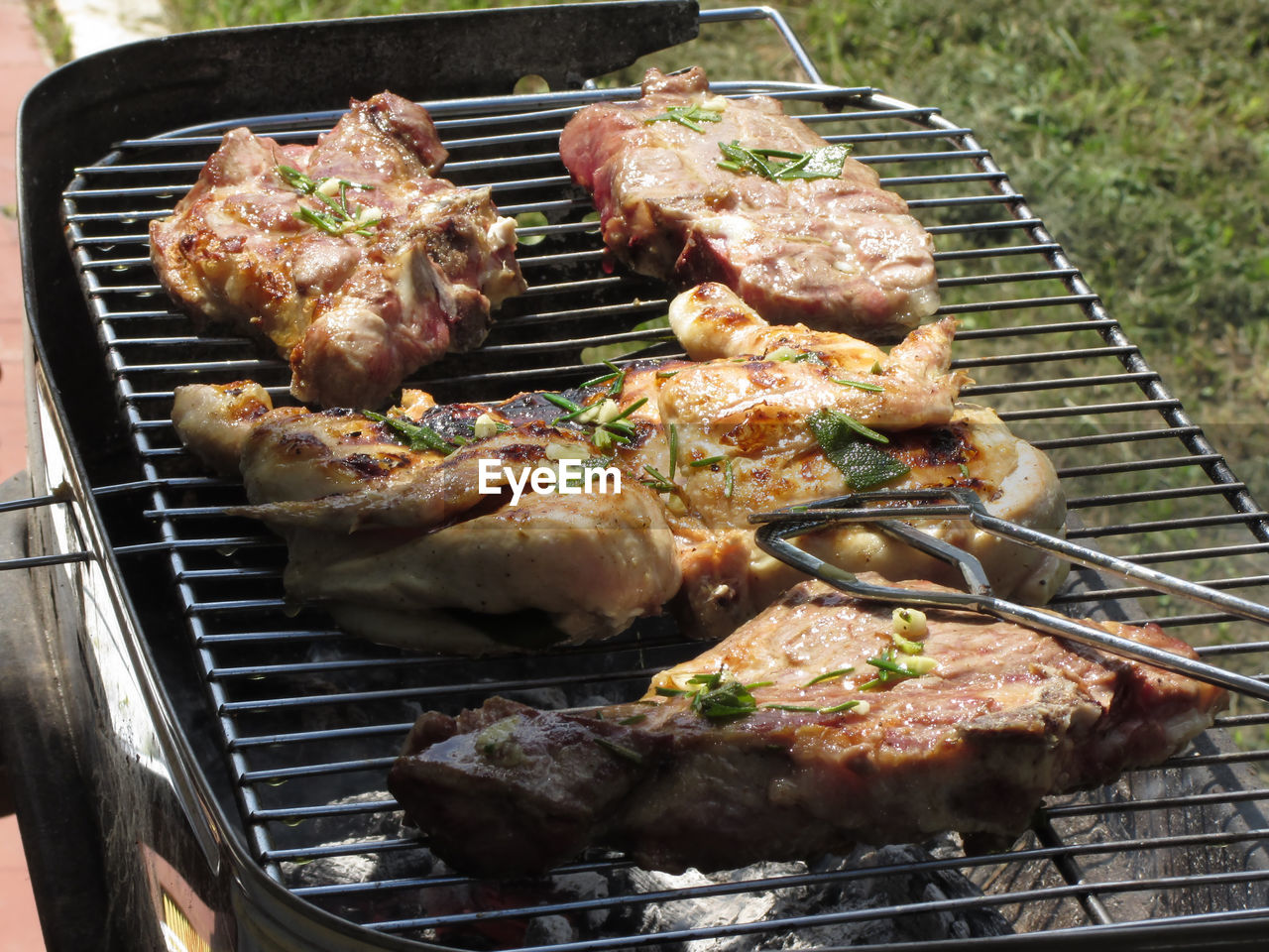 High angle view of chicken and steaks on barbecue