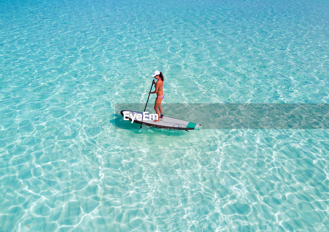 Woman paddleboarding in sea