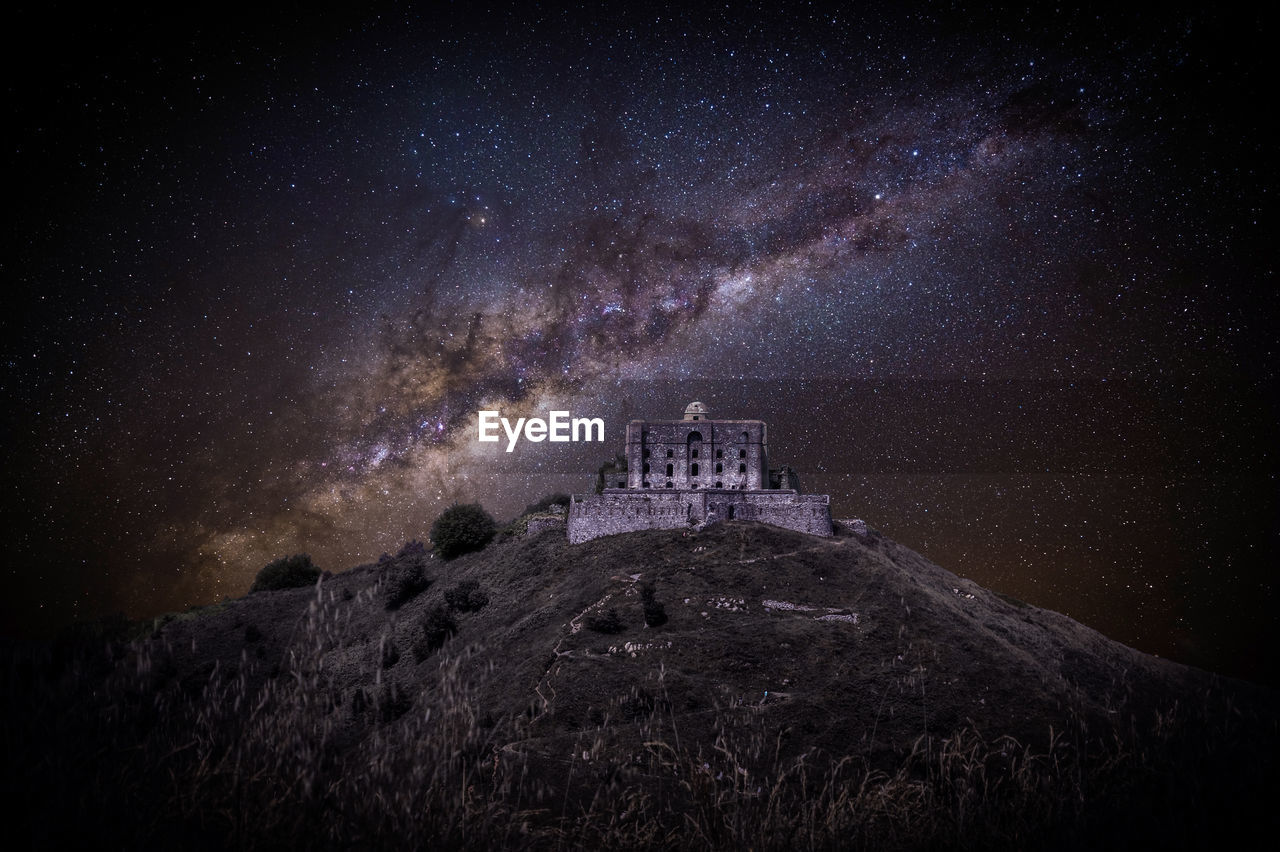 View of historical building against starry field at night