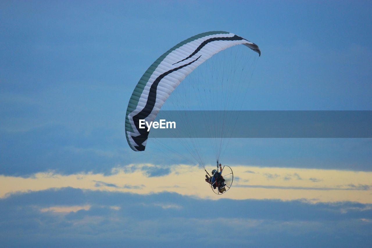 Low angle view of person paragliding against sky