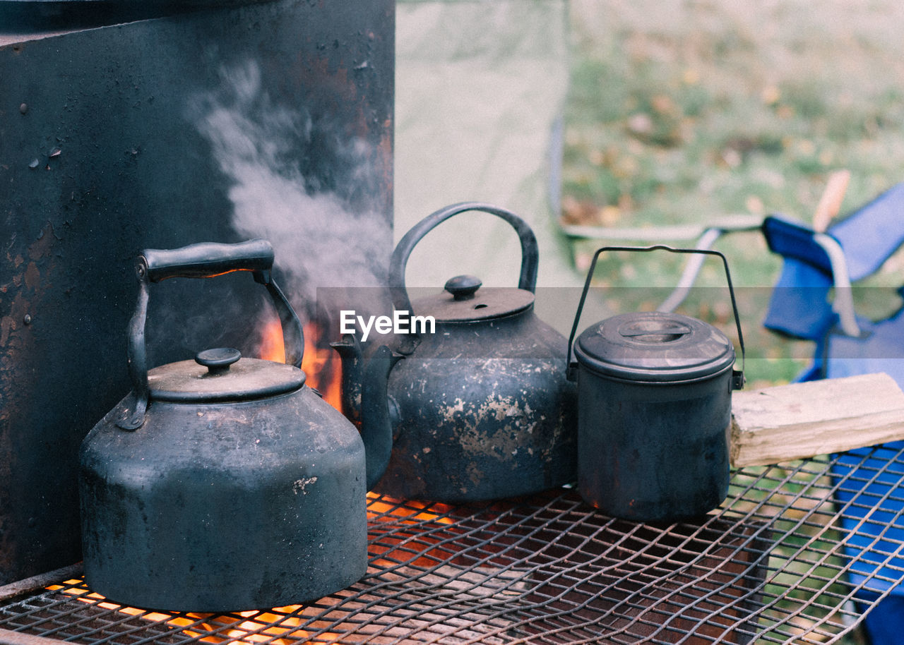 Close-up of rusty metal container on wood burning stove