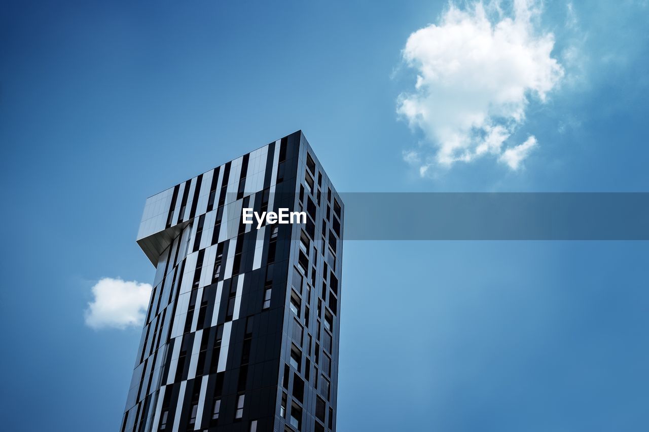 Low angle view of modern building against blue sky