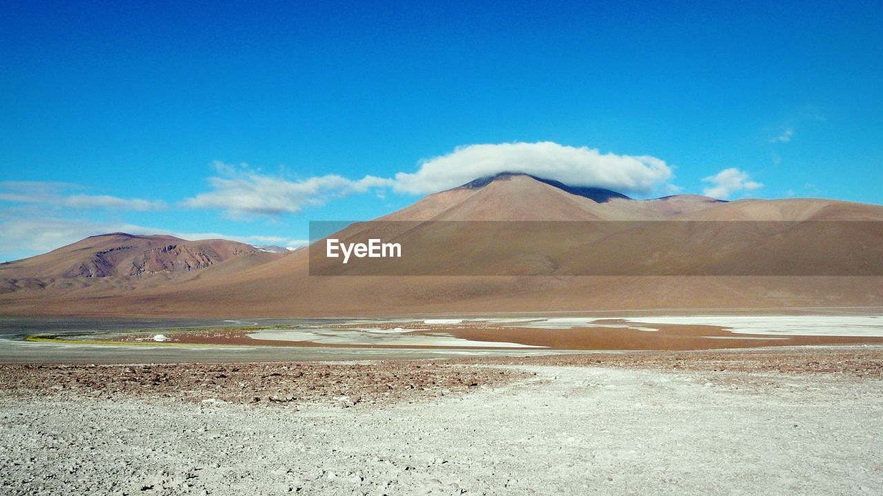 Scenic view of mountains against blue sky