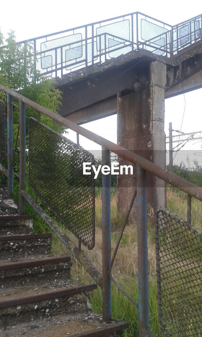 Rusty abandoned staircase of bridge