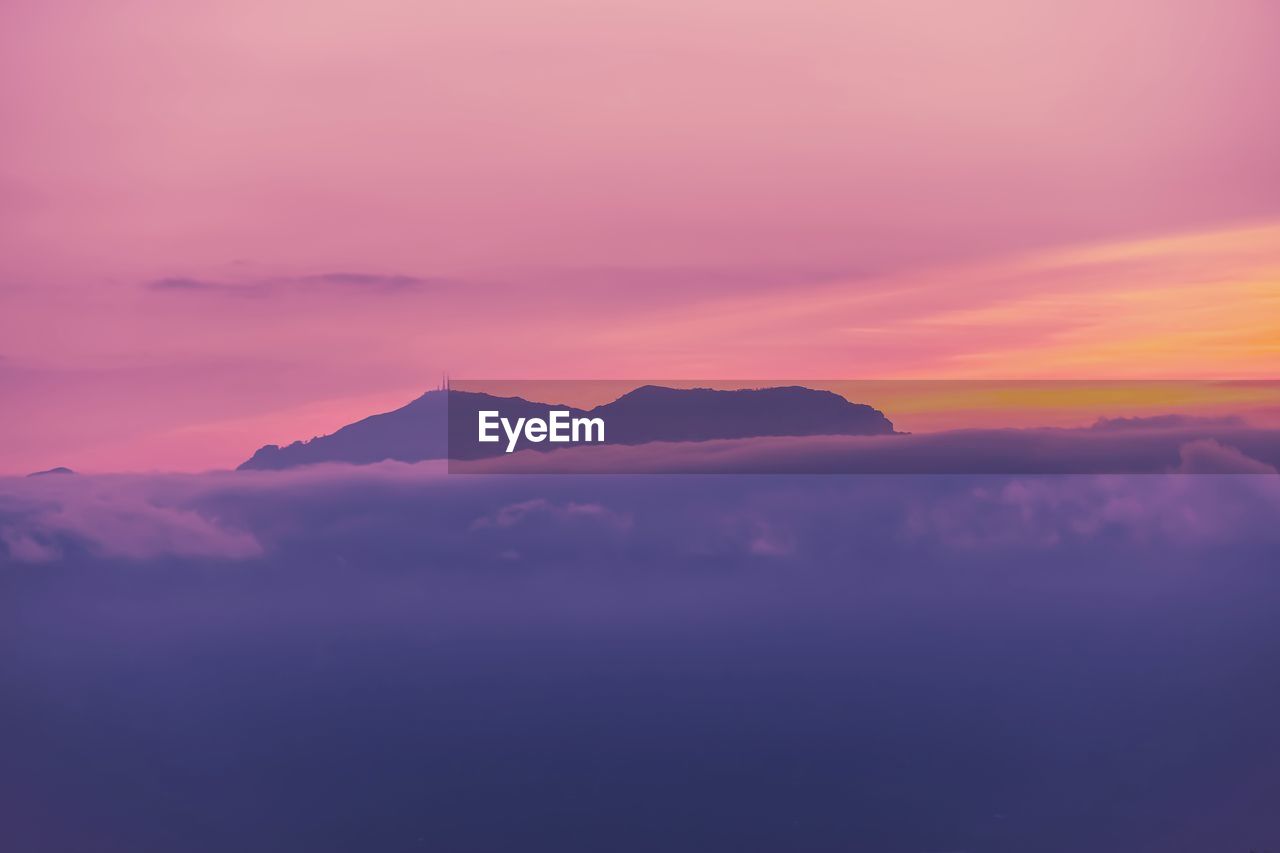 SCENIC VIEW OF MOUNTAINS AGAINST ROMANTIC SKY DURING SUNSET