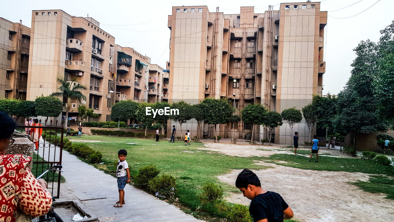 PEOPLE WALKING ON STREET IN FRONT OF BUILDINGS