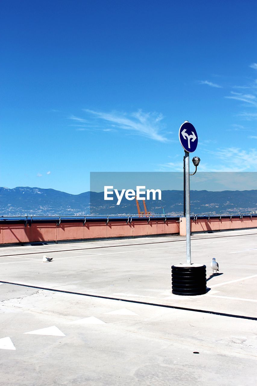 ROAD SIGN AGAINST BLUE SKY