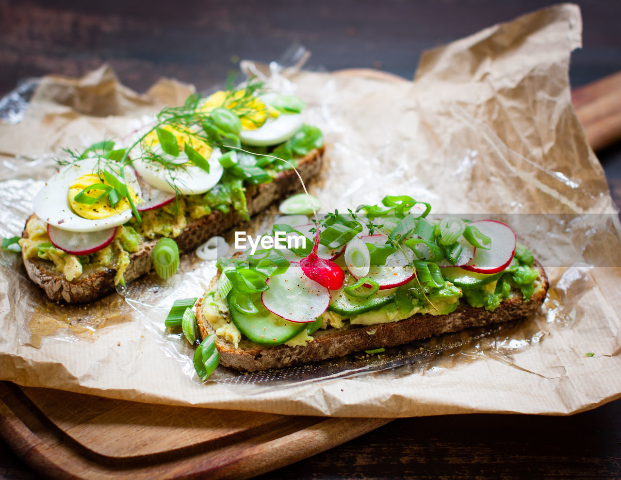 High angle view of open faced sandwiches on wax paper