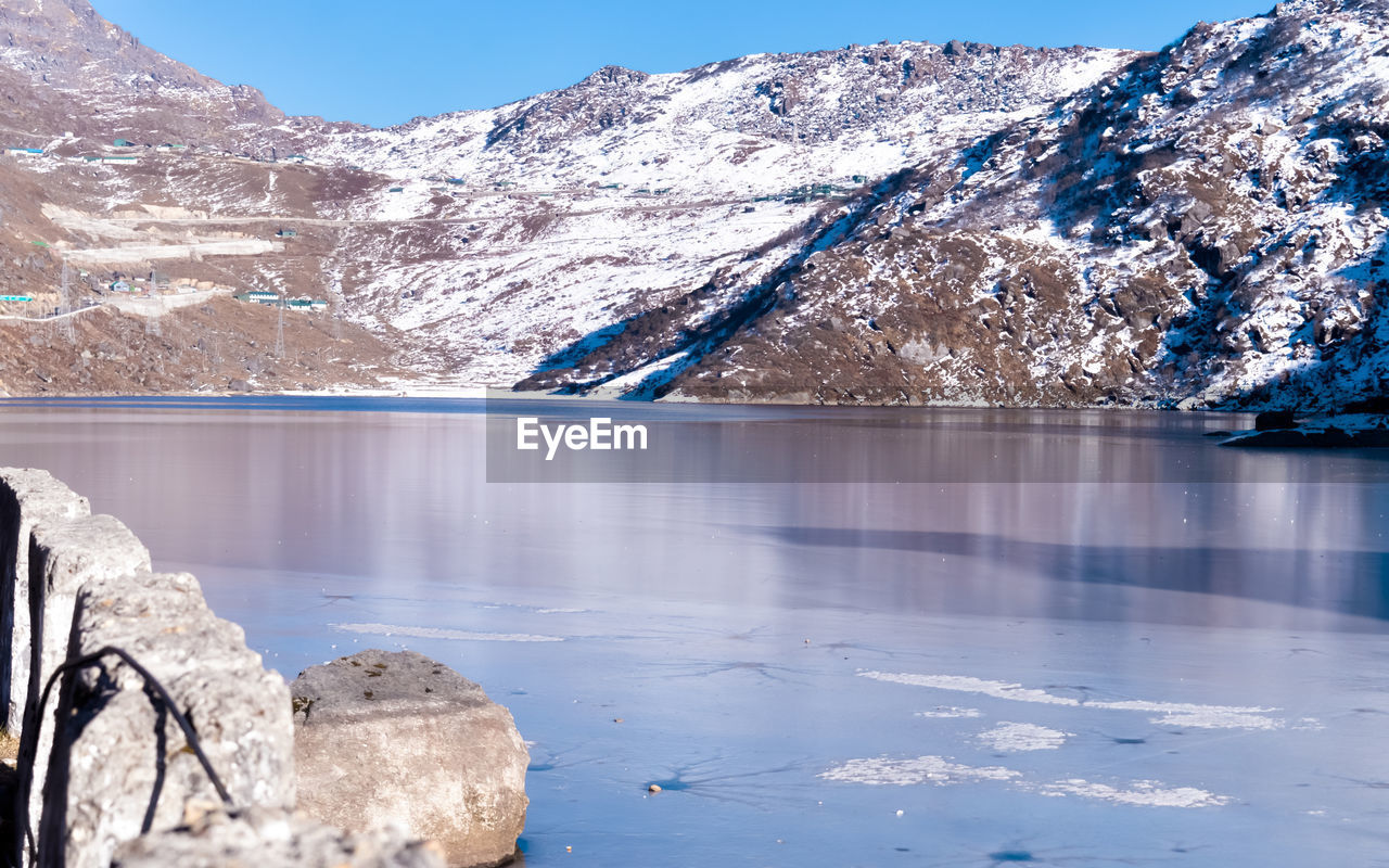 SCENIC VIEW OF LAKE AGAINST SNOWCAPPED MOUNTAINS