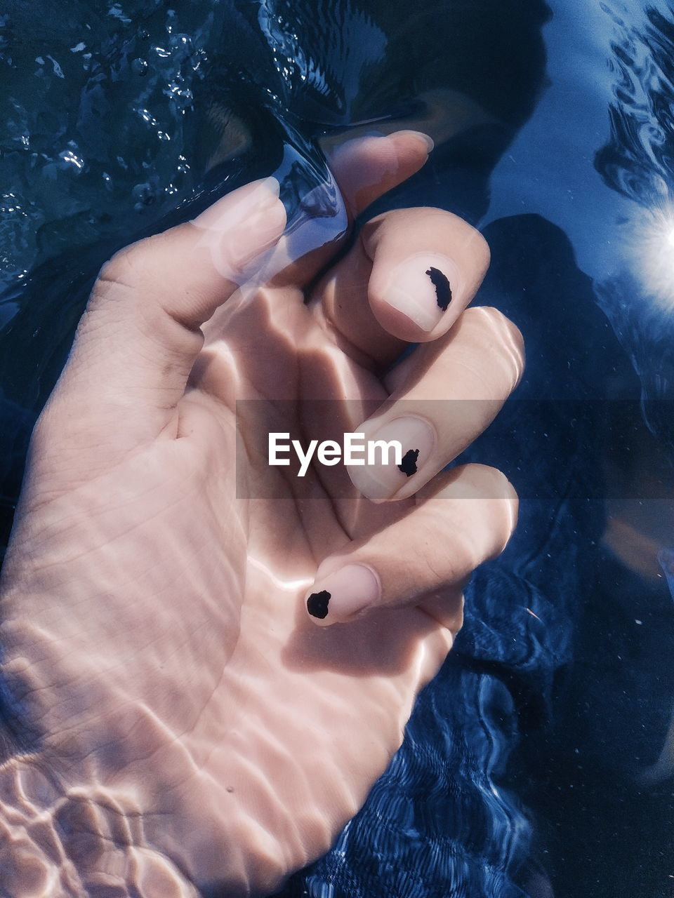 Cropped image of woman hand in water