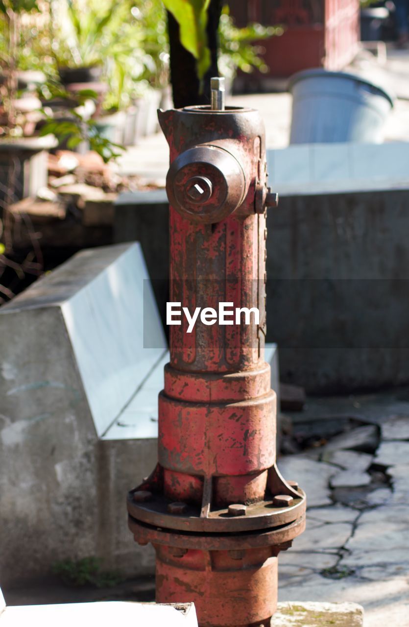 CLOSE-UP OF FIRE HYDRANT AGAINST METAL