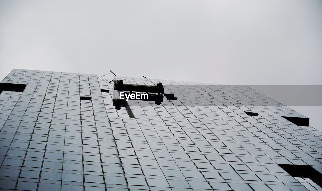 Low angle view of glass building against sky