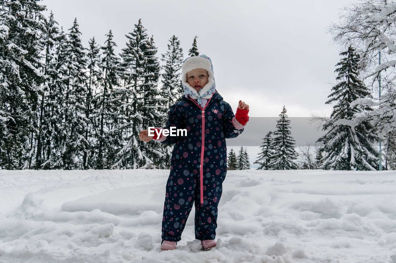 Little girl of 4 yo is playing in the snow