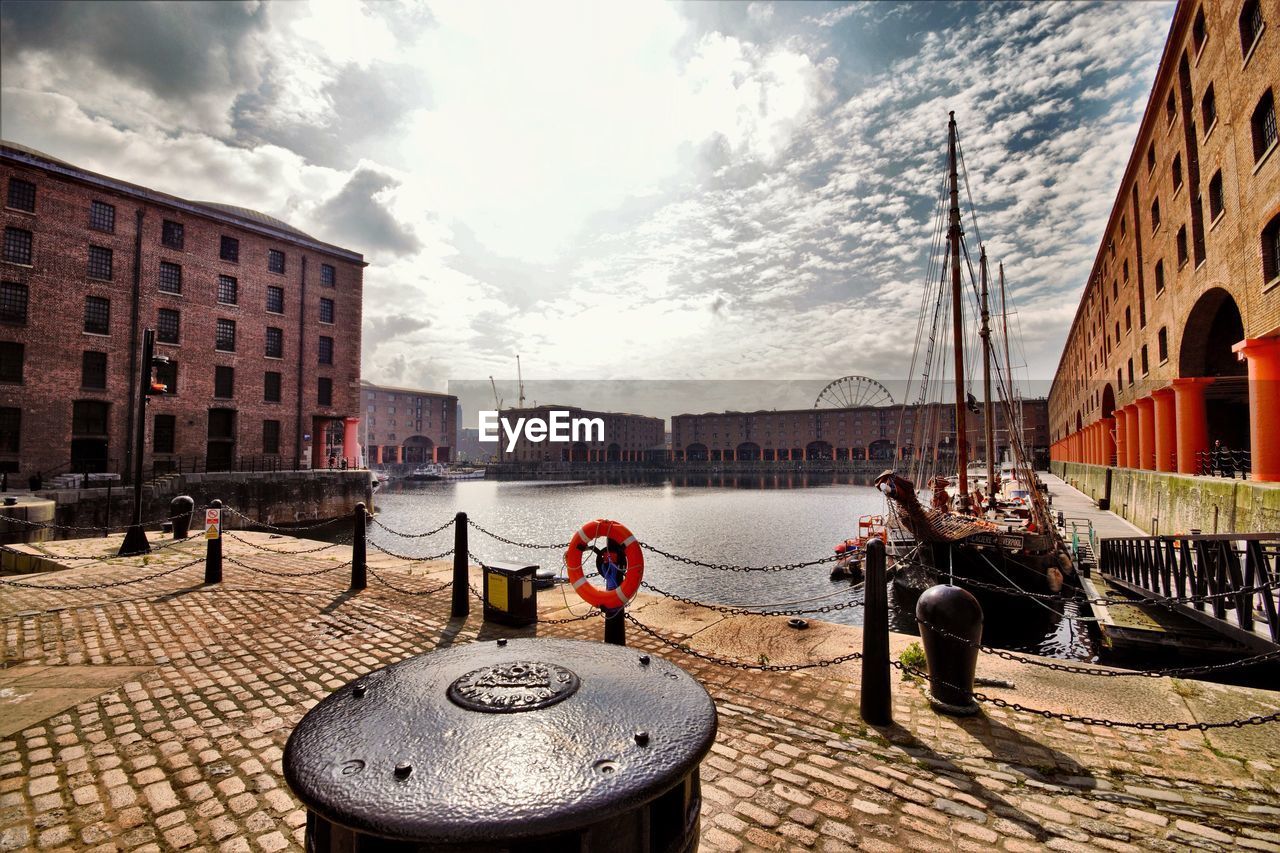 Albert dock against cloudy sky on sunny day