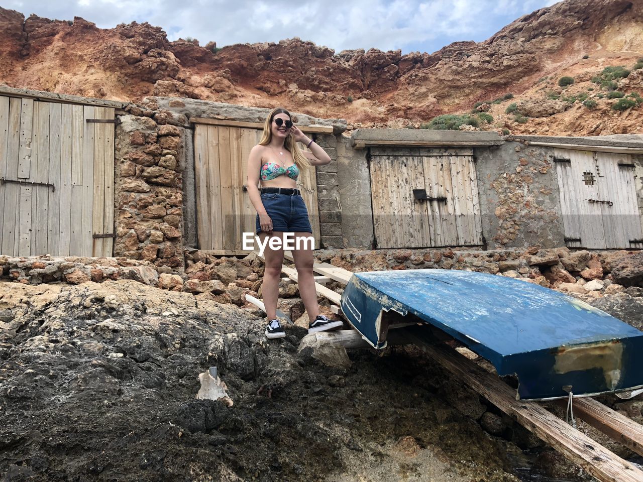 Full length of woman standing against abandoned building