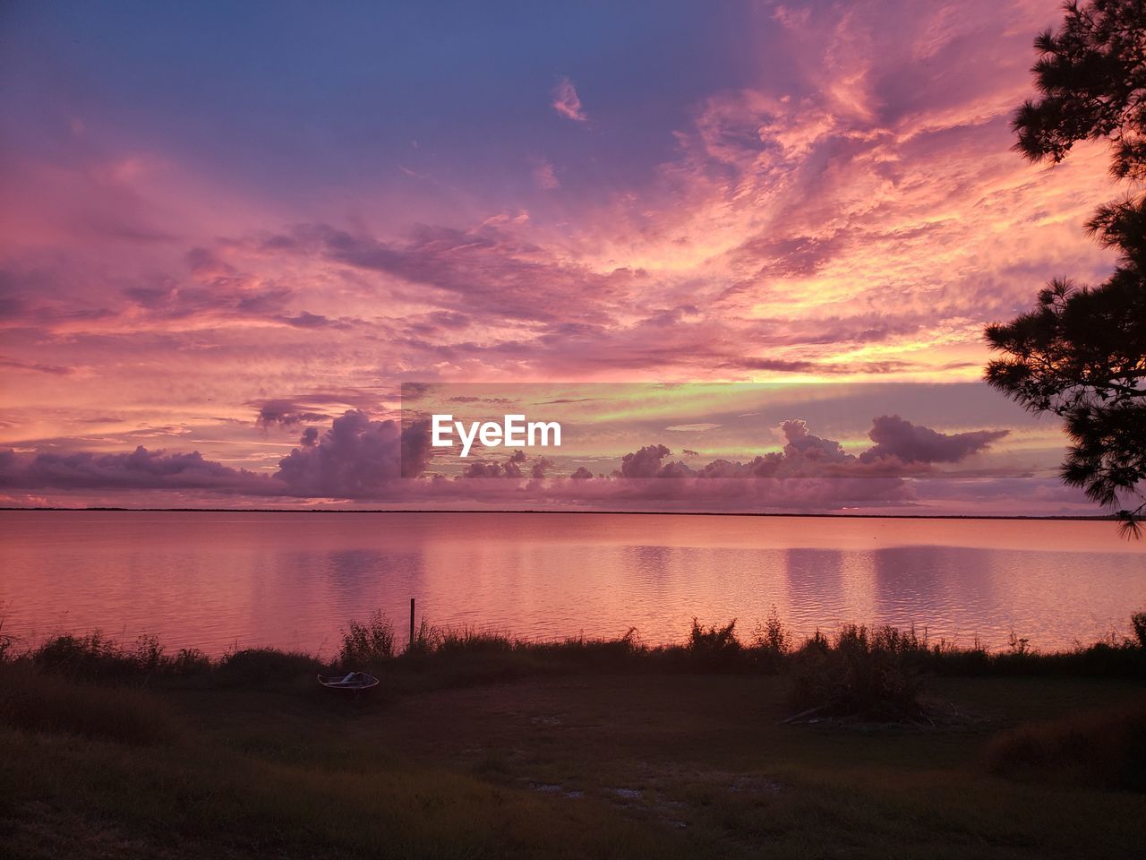 SCENIC VIEW OF LAKE AGAINST SKY AT SUNSET