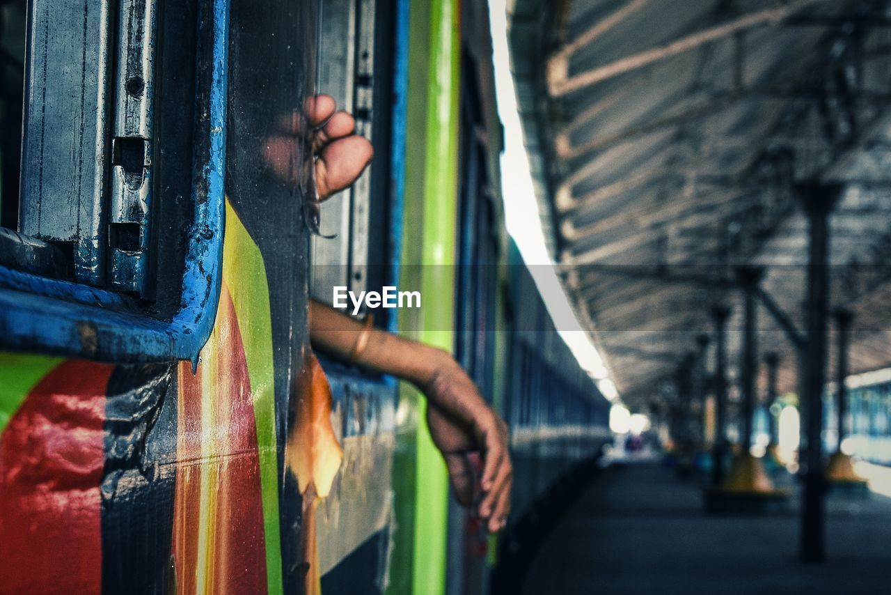 Cropped hands at train window in railroad station