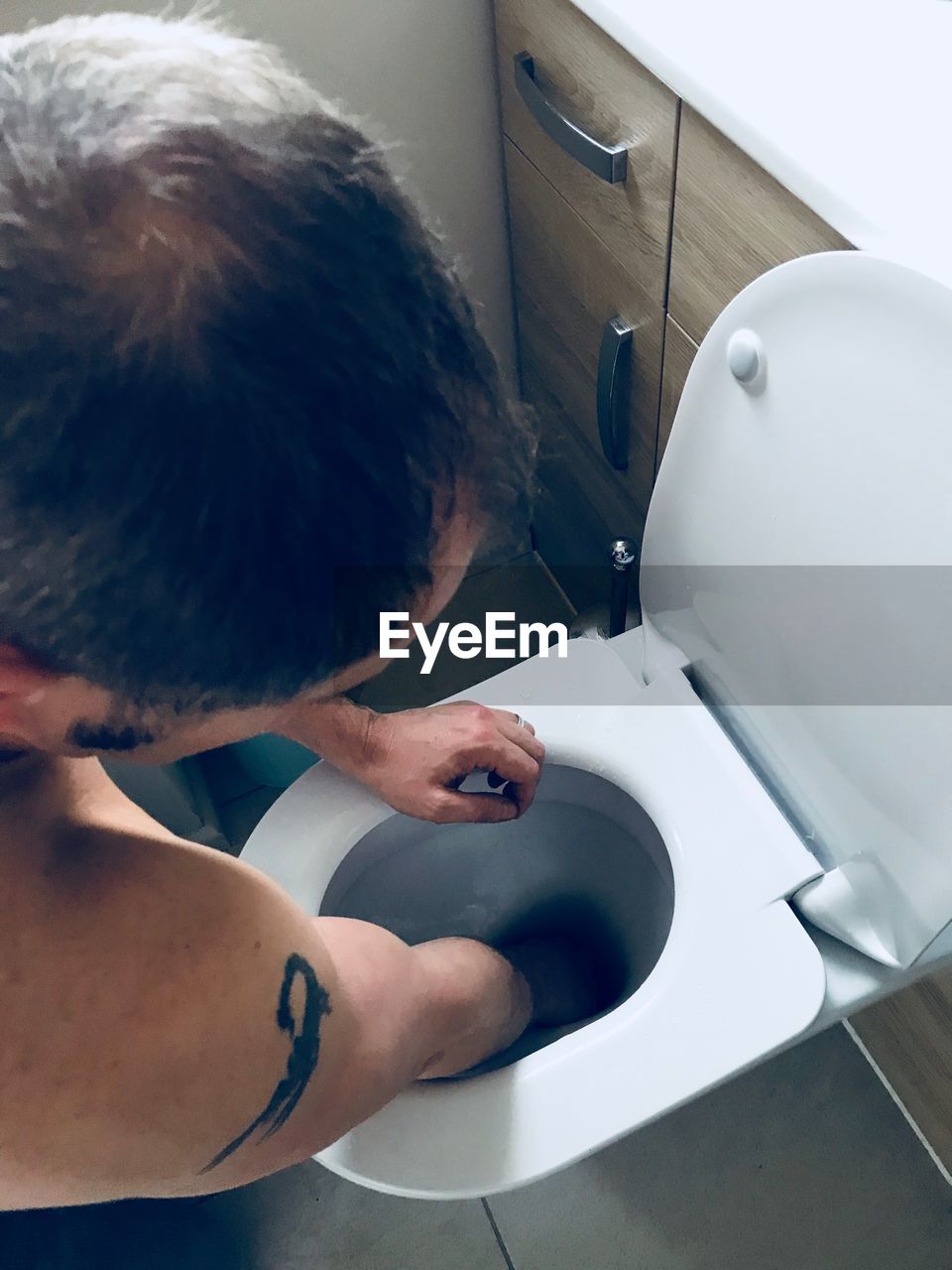 HIGH ANGLE VIEW OF MAN IN BATHTUB AT HOME