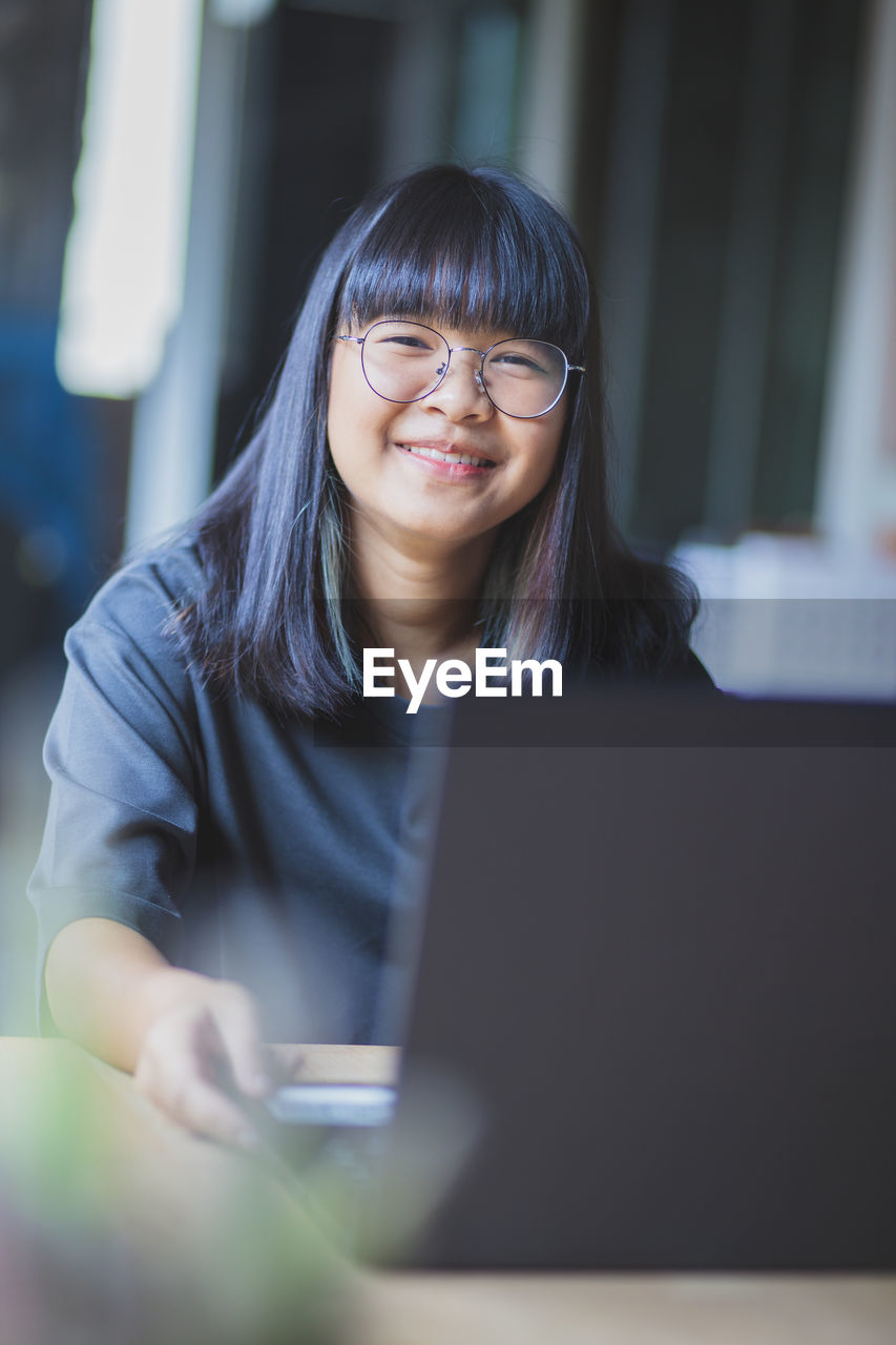 Portrait of smiling girl using laptop