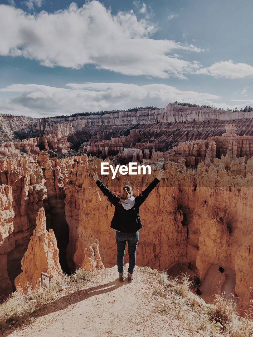 Rear view of woman with arms raised standing at bryce canyon