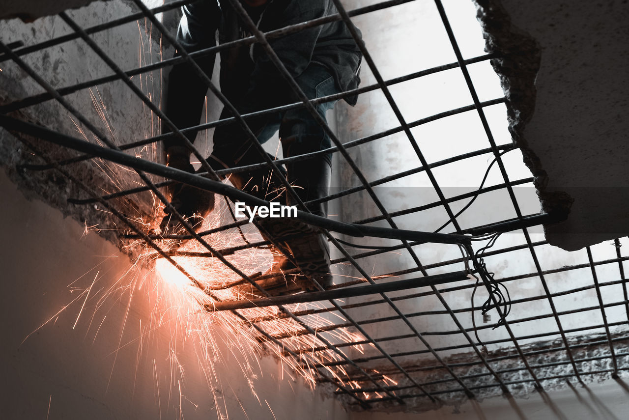 Low angle view of manual worker welding metal in factory