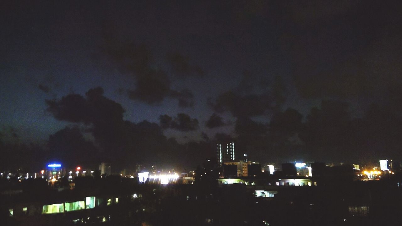 ILLUMINATED CITY AGAINST CLOUDY SKY