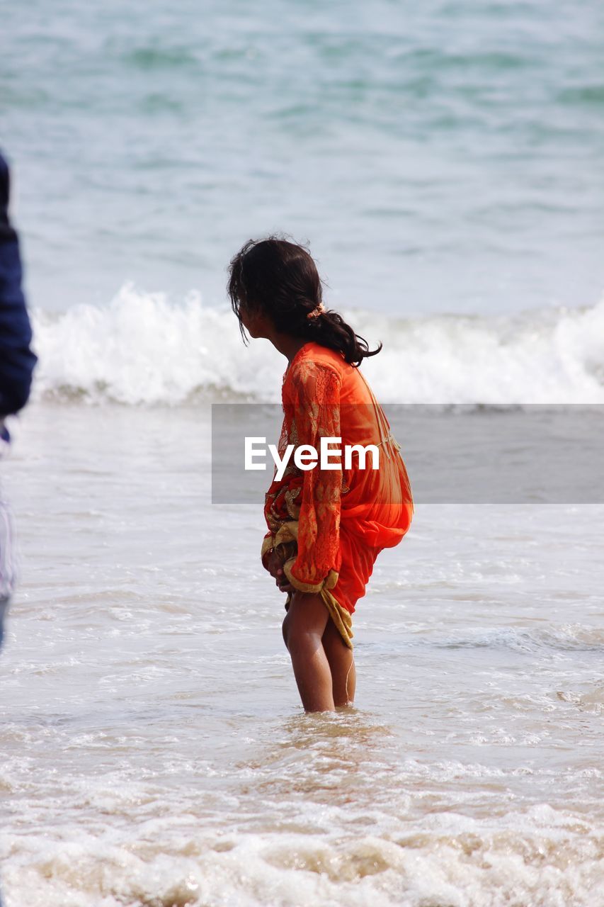 Side view of girl standing on beach