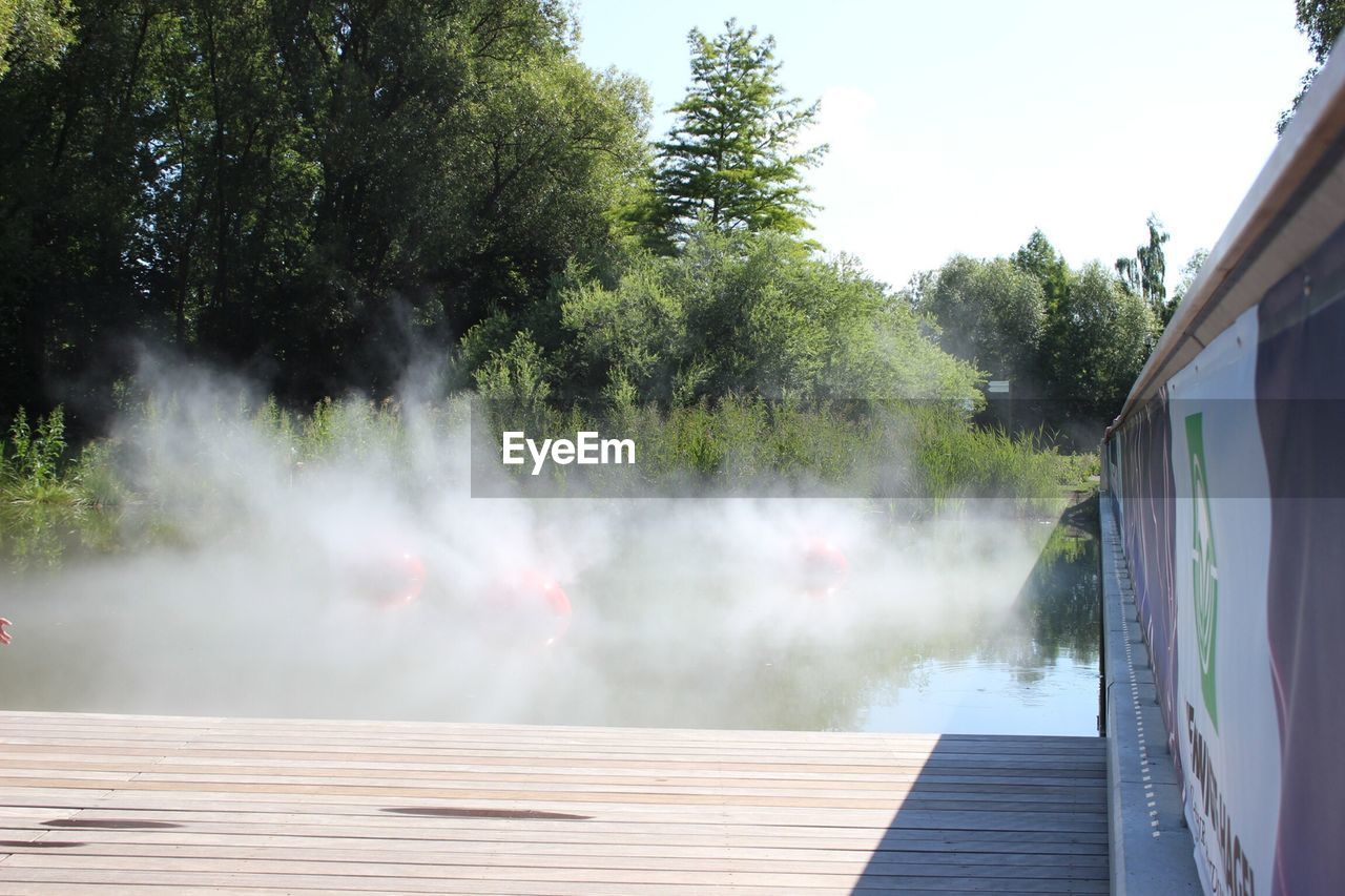 Smoke over lake by wooden plank
