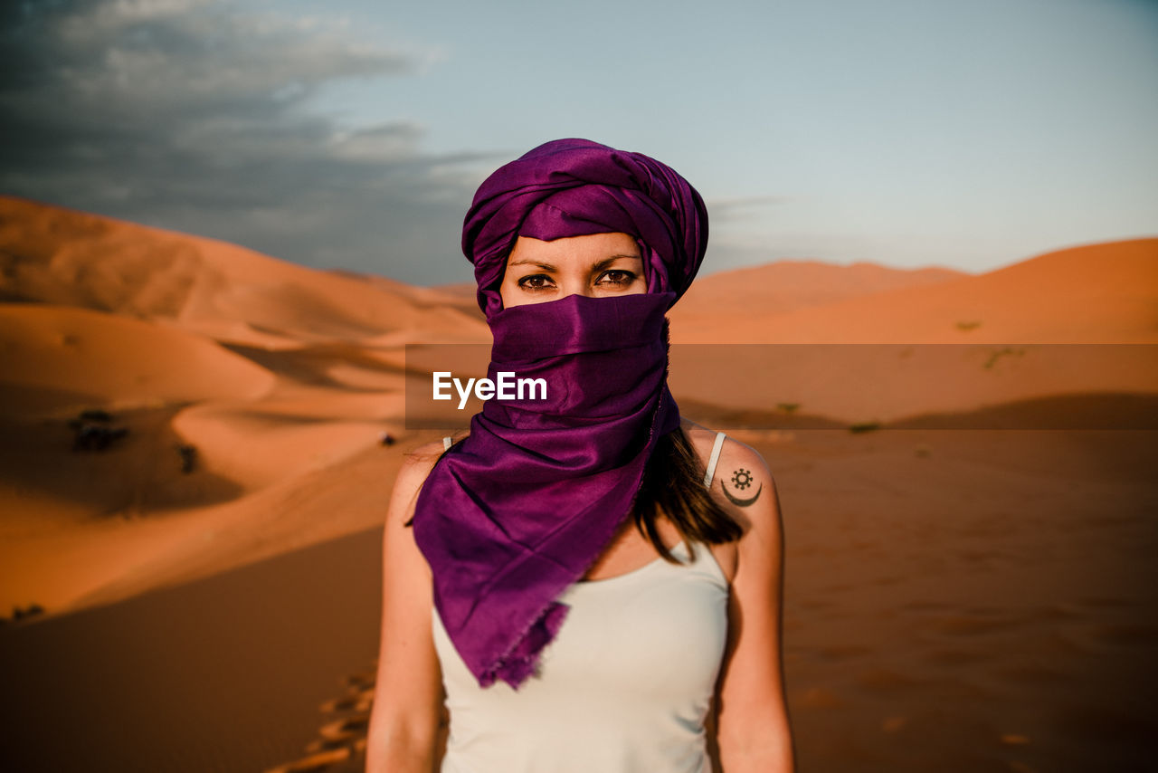 Close-up of a tourist woman wearing a purple turban looking at camera