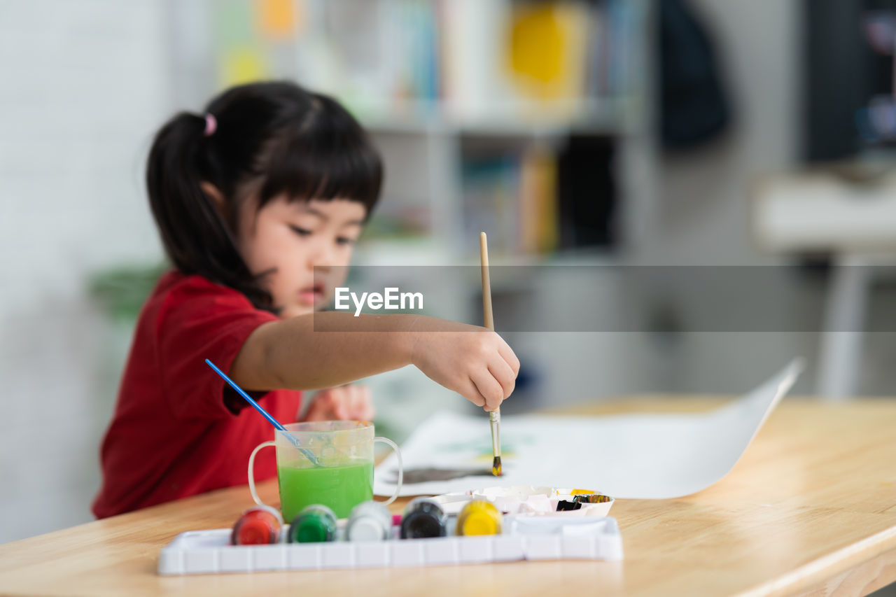 close-up of boy drawing on book at table