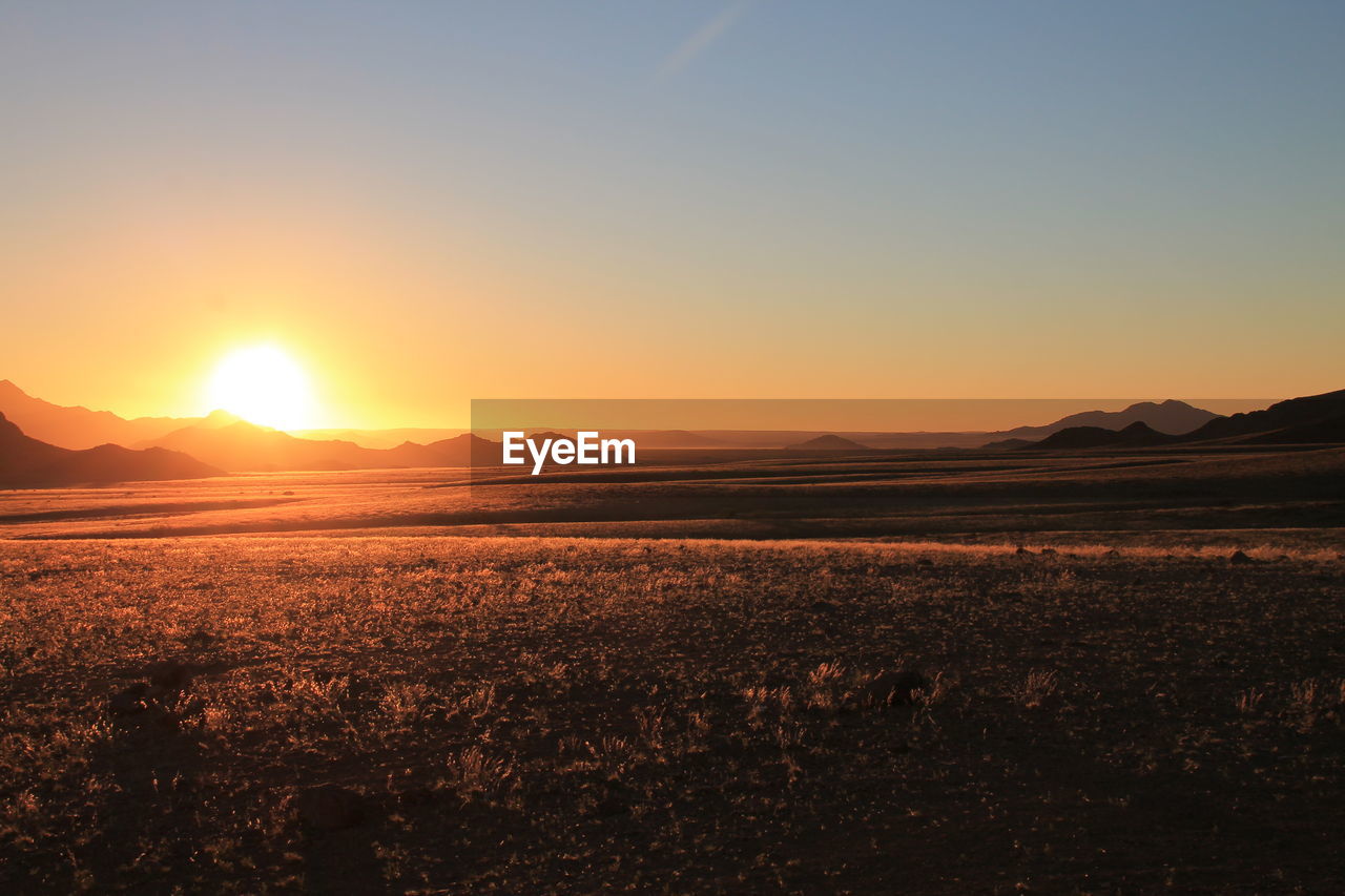 Scenic view of field against sky during sunset