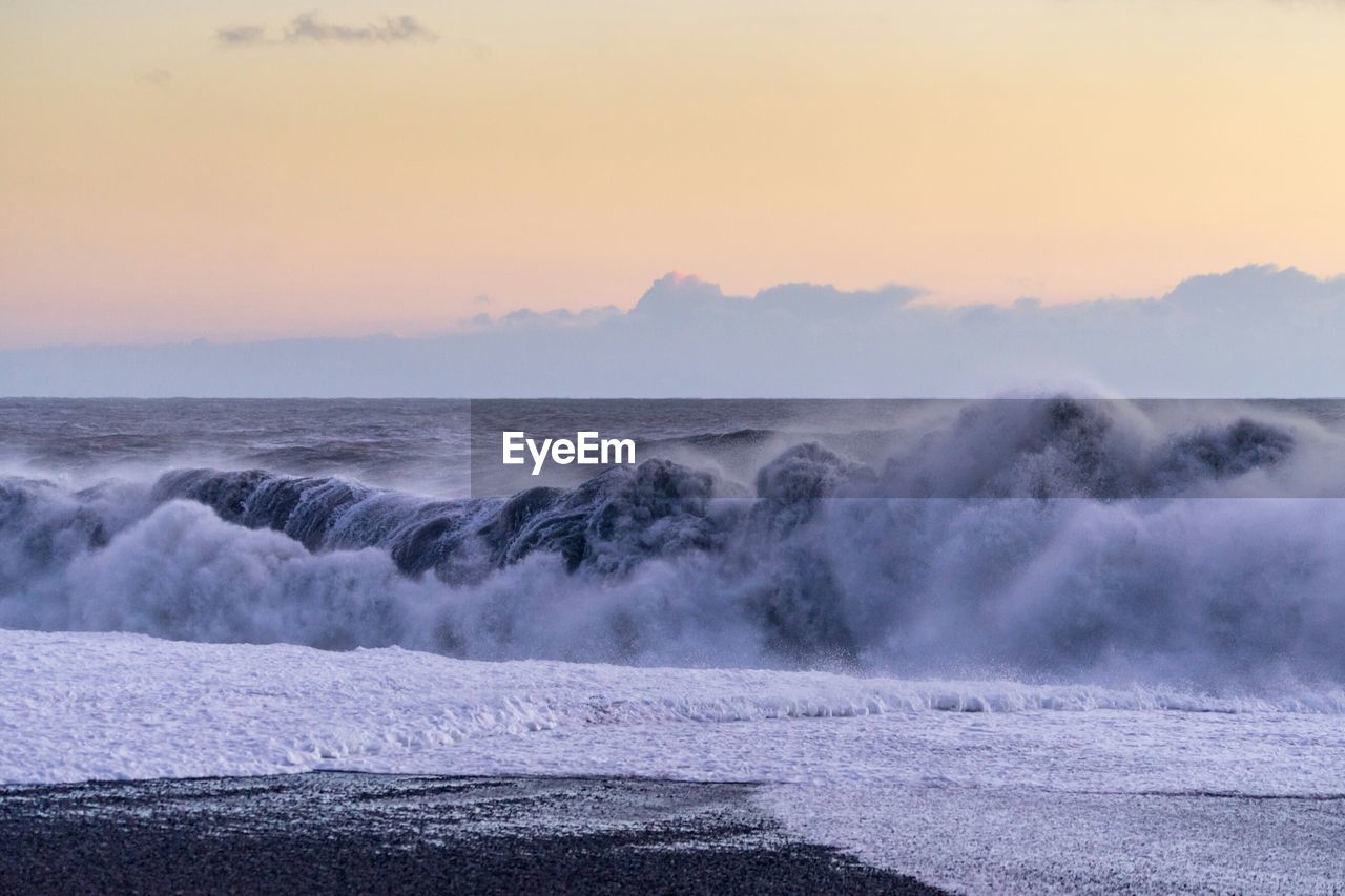 Scenic view of sea waves at sunset