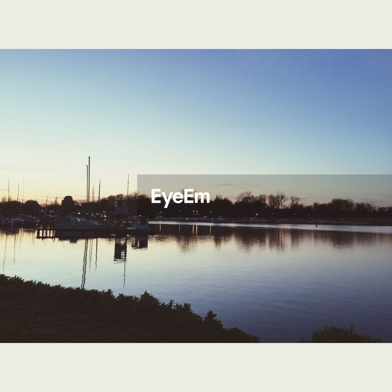 SCENIC VIEW OF CALM LAKE AT SUNSET