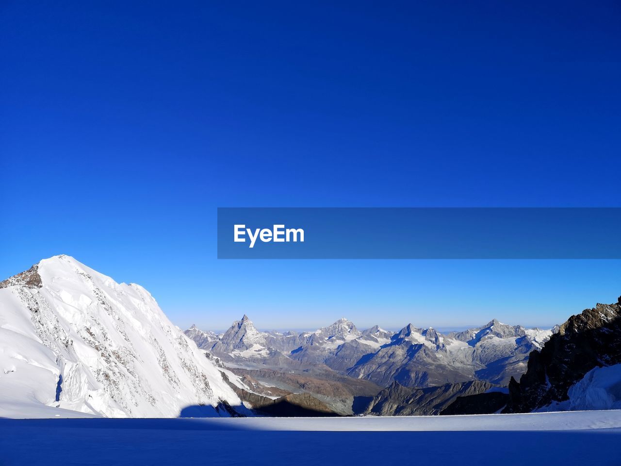 SNOWCAPPED MOUNTAINS AGAINST CLEAR BLUE SKY