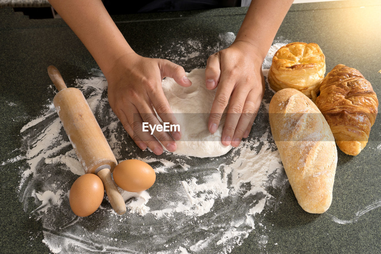 HIGH ANGLE VIEW OF MAN PREPARING BREAD