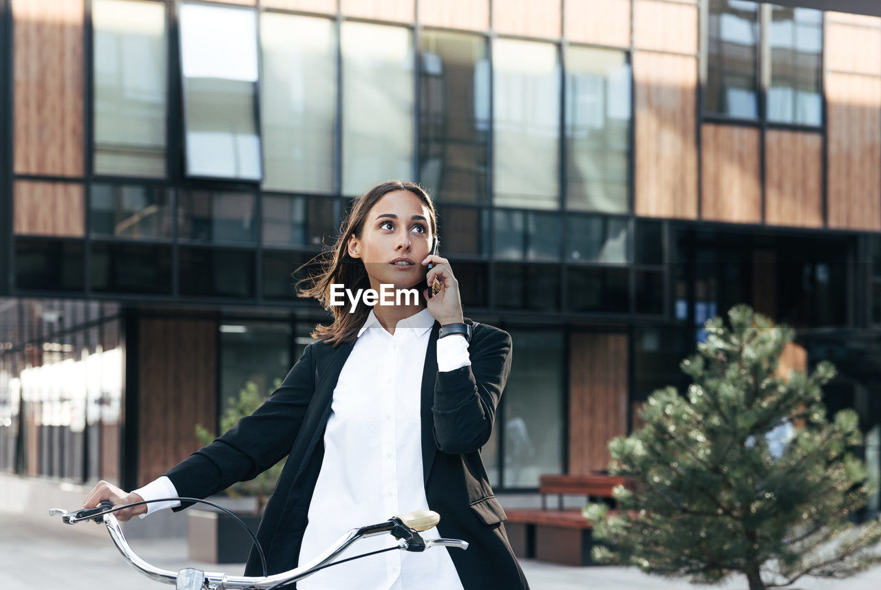 side view of young woman standing against building